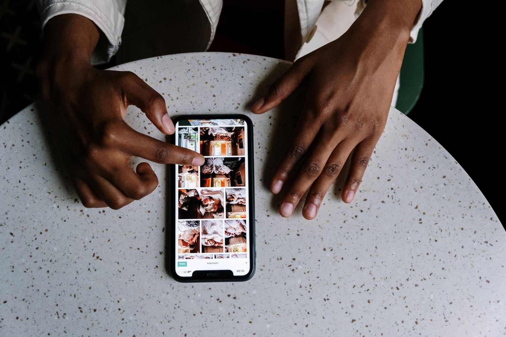 Person using a mobile phone to repost on Instagram at 12:28, wearing clothing, with text "12:28 cottonbro" visible on the screen